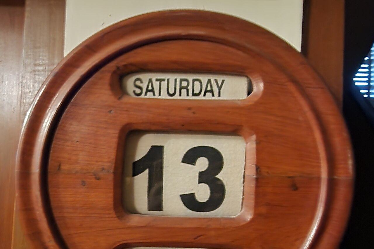 Un calendario de pared de madera que marca el sábado 13